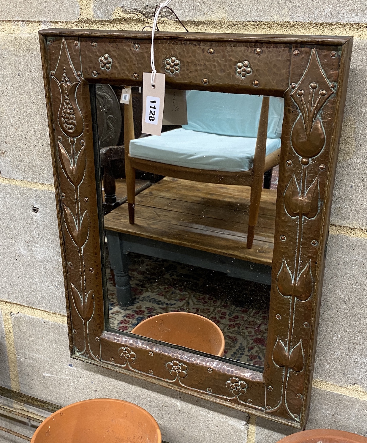 An early 20th century Newlyn style rectangular embossed copper mounted wall mirror, width 38cm, height 50cm